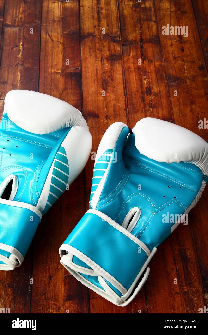 Zwei blaue Boxhandschuh isoliert auf einem hölzernen Hintergrund Stockfoto
