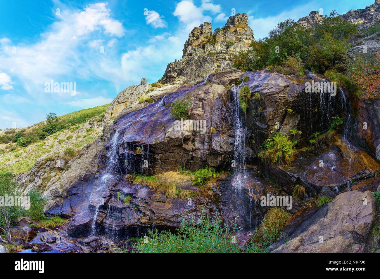 Kaskade von frischem Wasser, das zwischen den Felsen der hohen Berge fällt. Somosierra Madrid. Stockfoto