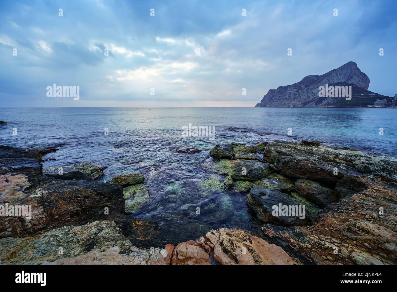 Große Felsen an der Küste und Wellen, die gegen sie krachen. Stockfoto