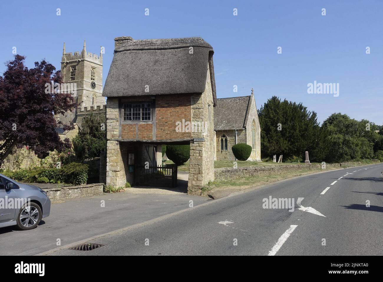 Lynch Gate mit reetgedeckten Häuschen über dem Eingang zur St. Peter & St. Paul Kirche Long Compton stammt aus dem 13.. Jahrhundert wurde ich umfassend restauriert Stockfoto