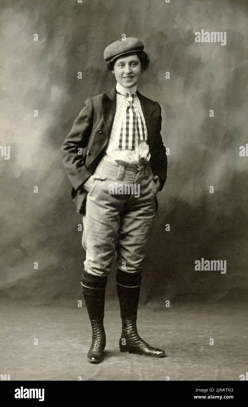 Formelles Vintage-Studioporträt in Schwarz und Weiß mit androgyner Person, die ein Herrenfahrrad oder einen Golfanzug mit Mütze und Schnürstiefeln um 1895 trägt Stockfoto