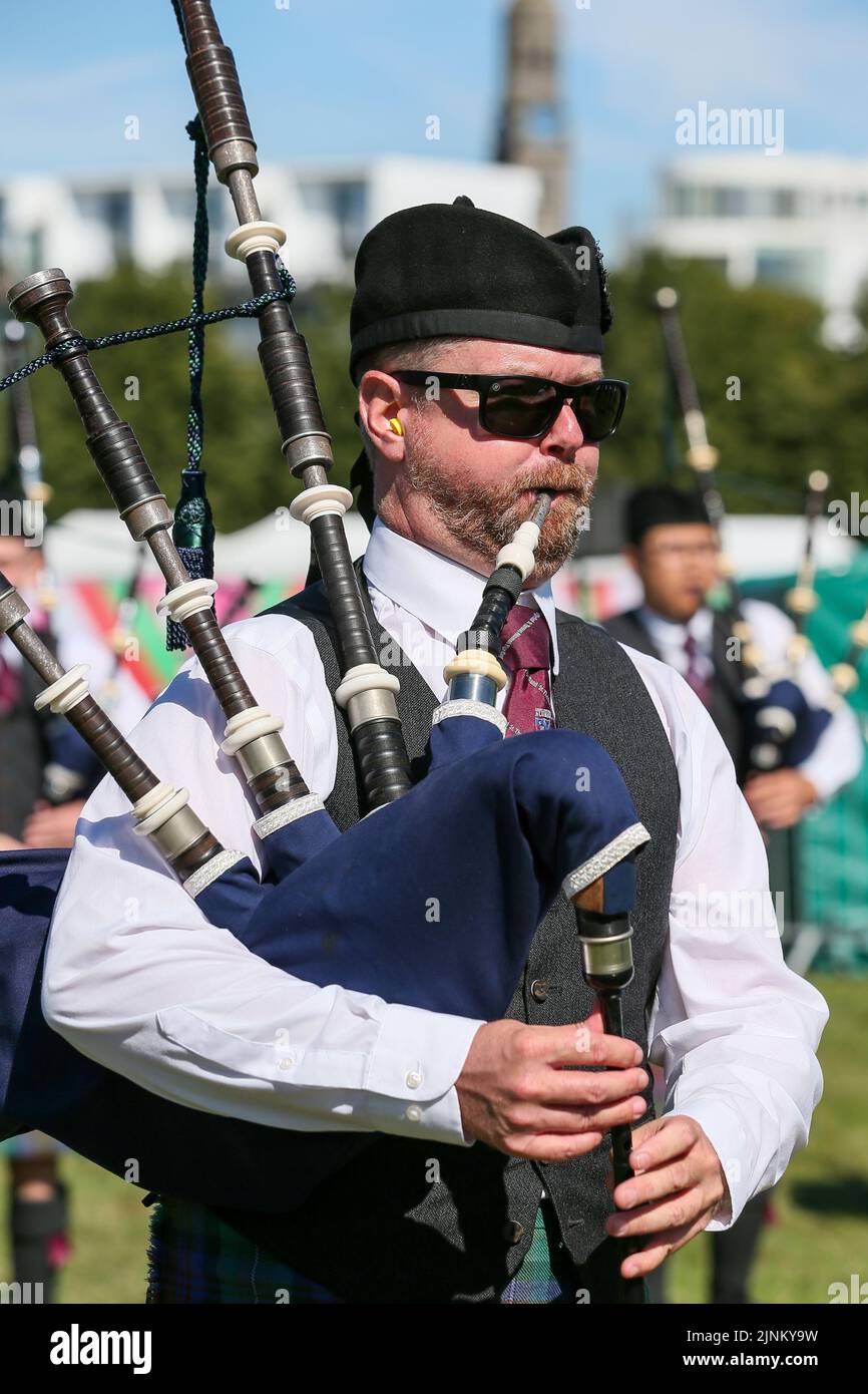 Glasgow, Großbritannien. 12. August 2022. Die World Pipe Band Championship wurde nach der Aussetzung im Jahr 2019 aufgrund von Covid-Beschränkungen wieder aufgenommen, und in diesem Jahr nehmen 150 Pfeifenbänder aus der ganzen Welt Teil. Der Wettbewerb findet über 2 Tage statt, und am zweiten Tag (Samstag) wird aufgrund des warmen und sonnigen Wetters erwartet, dass er Rekordmengen anzieht. Piper mit St. Thomas Alumni, USA. Kredit: Findlay/Alamy Live Nachrichten Stockfoto