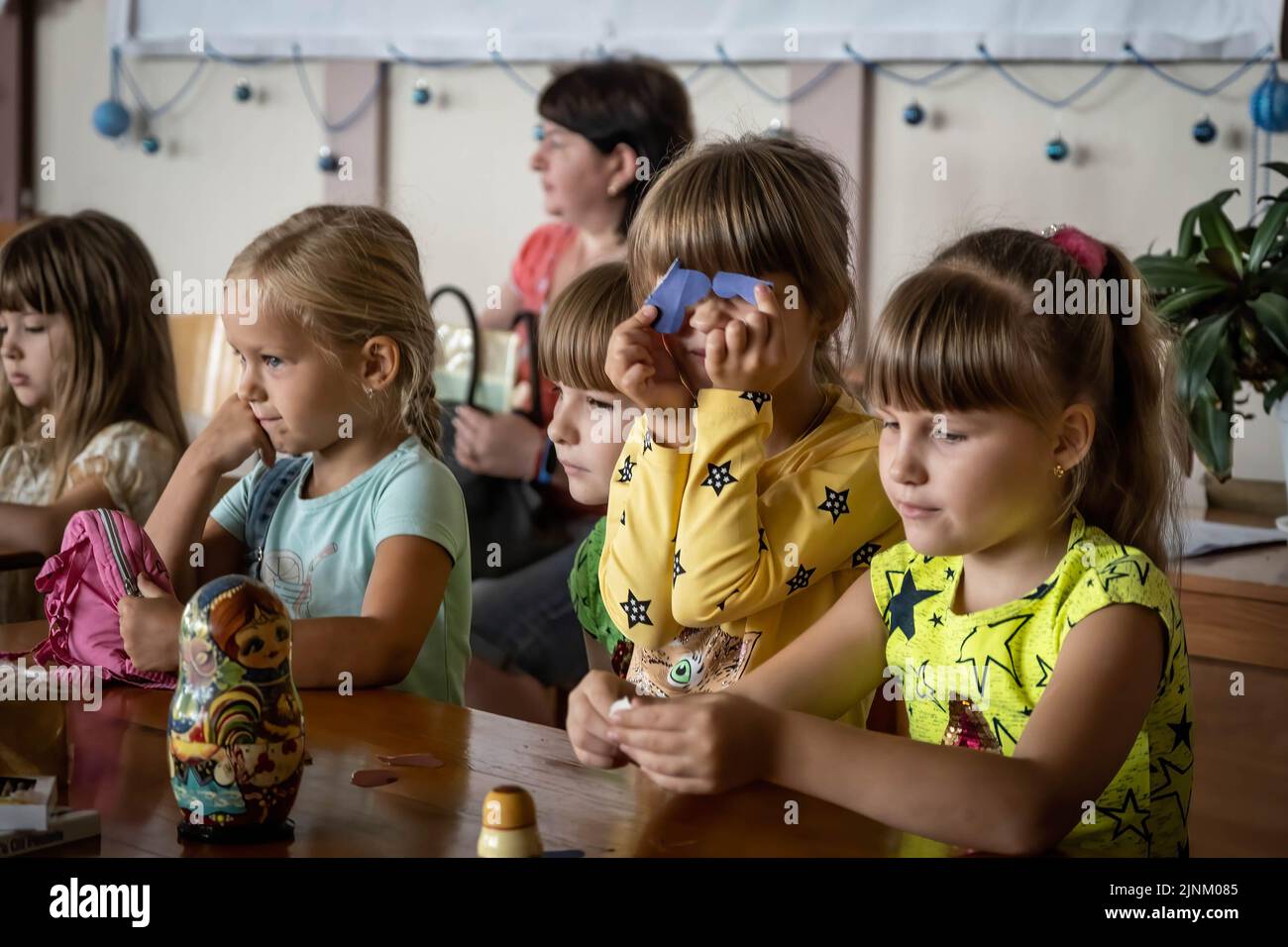 Kinder, die an einem Sonntagsgottesdienst in einer katholischen Kirche in Slovyansk, Donbas, teilnahmen. Obwohl die Stadt ständig stark von russischen Artillerien und Raketen bombardiert wird, planen einige Bewohner immer noch, in der Stadt Slowjansk zu bleiben, die eine Bevölkerung von 106.972 (2021 estens.) hatte, die heute als eine der wichtigsten strategischen Städte in der Donezker Region im Donbass gilt. Seit Kriegsbeginn wurden über 80 % der Zivilbevölkerung aus dem Krieg evakuiert. Stockfoto