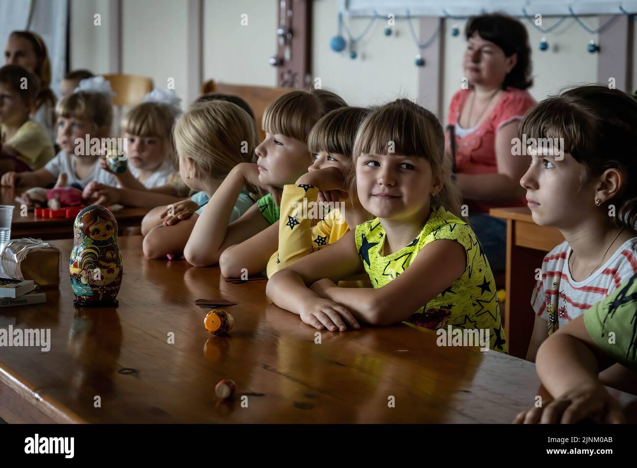Kinder besuchen einen Kindersonntagsgottesdienst in einer katholischen Kirche in Slowjansk, Donbas. Obwohl die Stadt ständig stark von russischen Artillerien und Raketen bombardiert wird, planen einige Bewohner immer noch, in der Stadt Slowjansk zu bleiben, die eine Bevölkerung von 106.972 (2021 estens.) hatte, die heute als eine der wichtigsten strategischen Städte in der Donezker Region im Donbass gilt. Seit Kriegsbeginn wurden über 80 % der Zivilbevölkerung aus dem Krieg evakuiert. Stockfoto