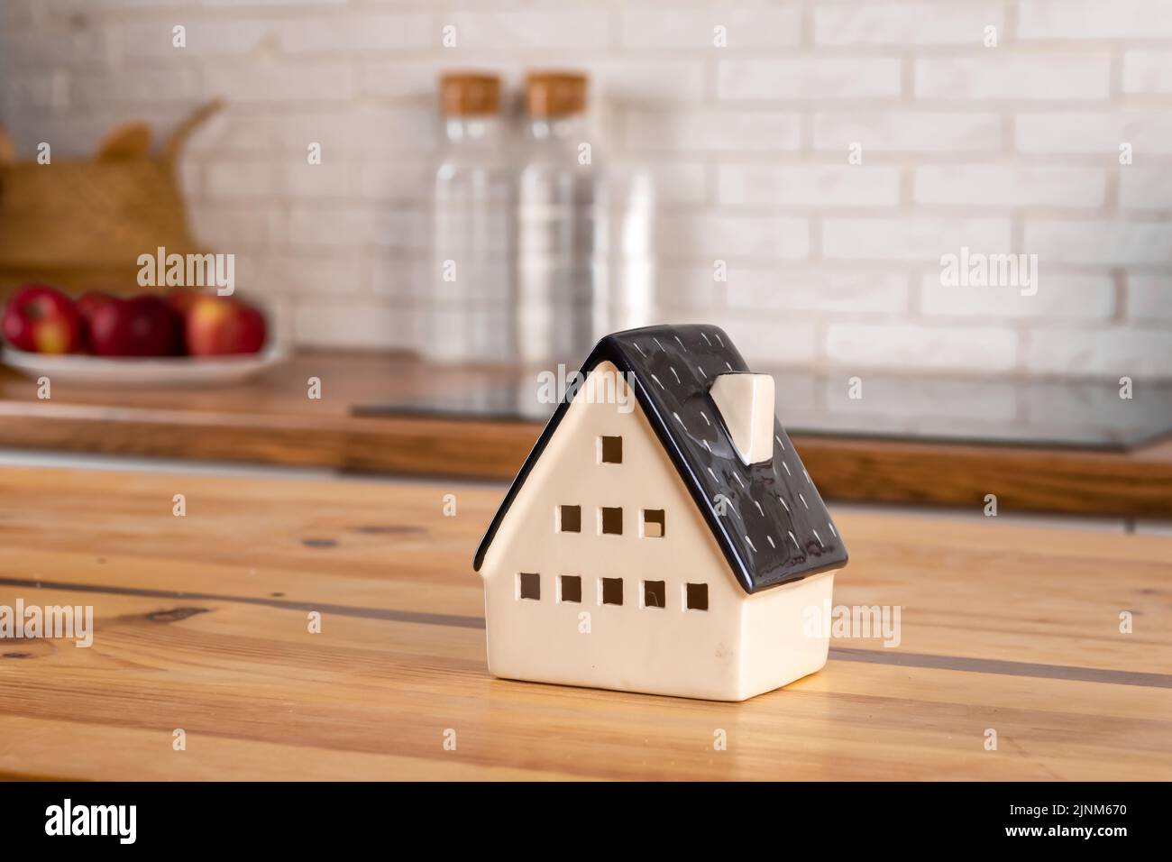 Ein Modell eines Hauses auf dem Hintergrund von Küchenmöbeln. Das Konzept des Kaufs eines Hauses, Hypothek Immobilien, Wohnküche Interieur Stockfoto
