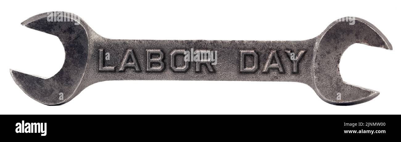 Alter Schlüssel isoliert auf weiß mit den Worten Labor Day eingestanzt in das Metall Stockfoto
