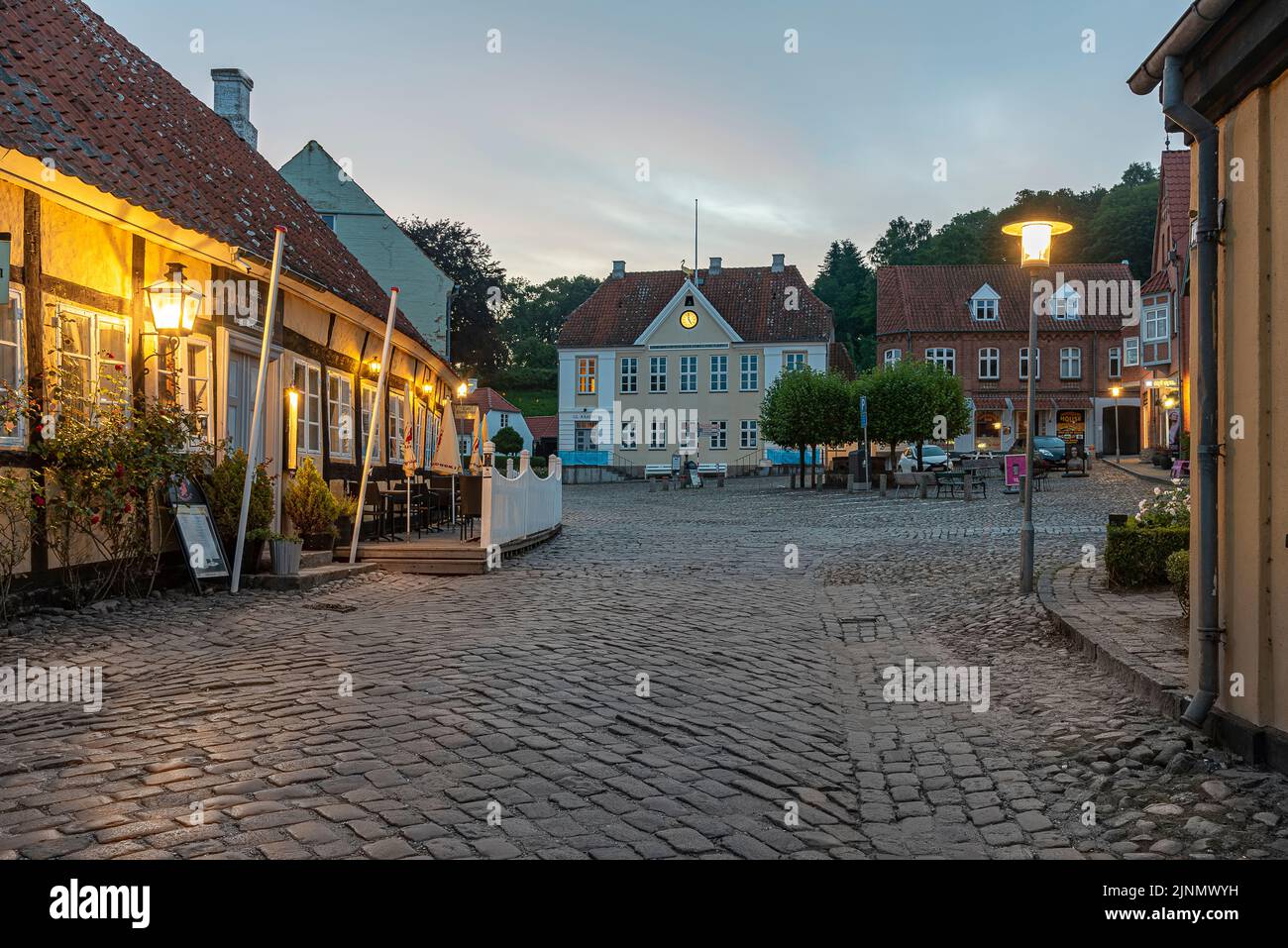 Alter gepflasterter Platz mit einem Fachwerkhotel in der Abendstunde, Mariager, Dänemark, 7. August 2022 Stockfoto