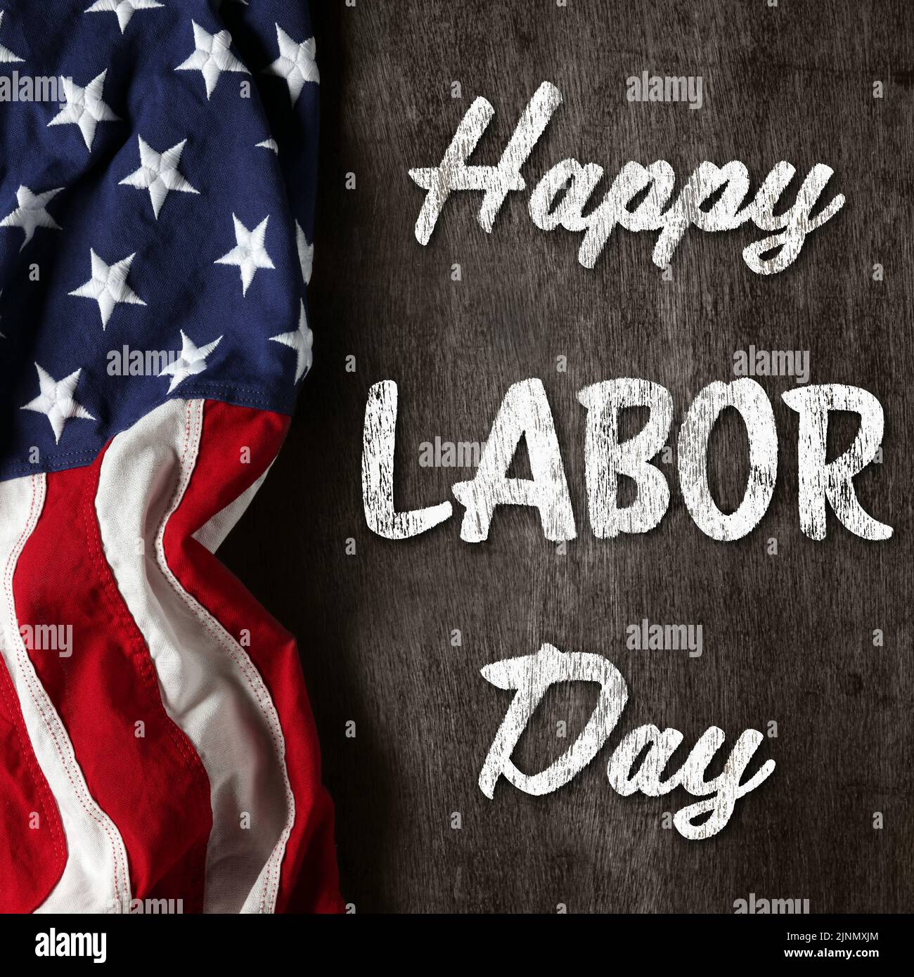 US-amerikanische Flagge auf abgenutztem schwarzem Hintergrund. Zur Feier des USA Labor Day. Mit Happy Labor Day Text. Stockfoto
