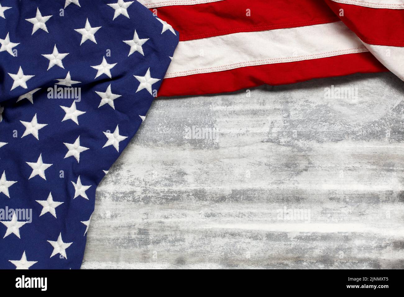 US-amerikanische Flagge auf abgenutztem weißen Holzhintergrund. Für den USA Memorial Day, den Veteran's Day, den Labor Day oder die Feier des 4. Juli. Mit leerem Leerzeichen für tex Stockfoto