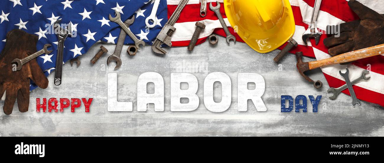 US-amerikanische Flagge mit Arbeitswerkzeugen auf abgenutztem weißem Holzhintergrund. Zur Feier des USA Labor Day. Mit Happy Labor Day Text. Stockfoto