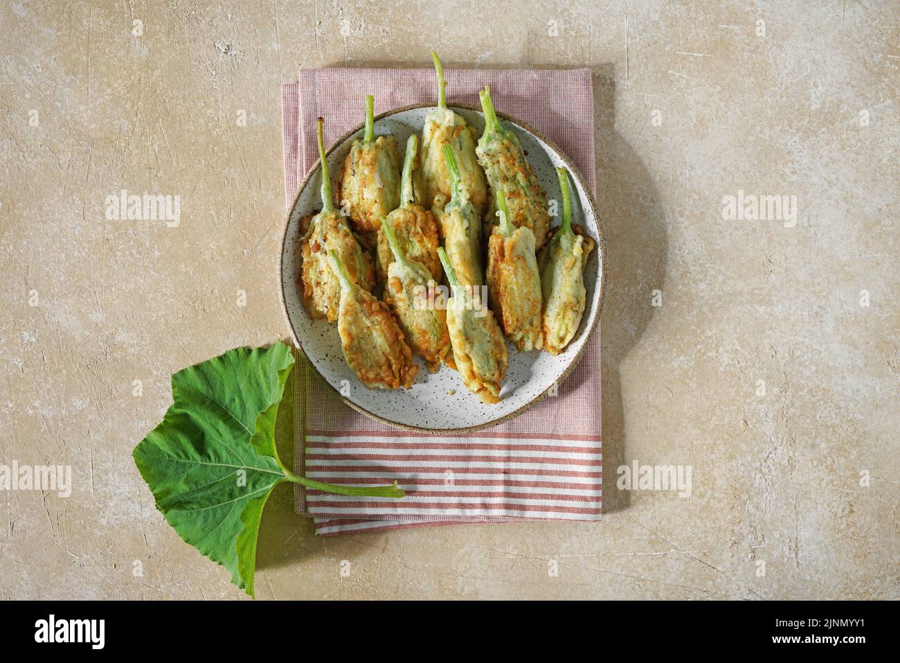 Gebratene Zucchini-Blumen gefüllt mit Frischkäse auf dem Teller ...