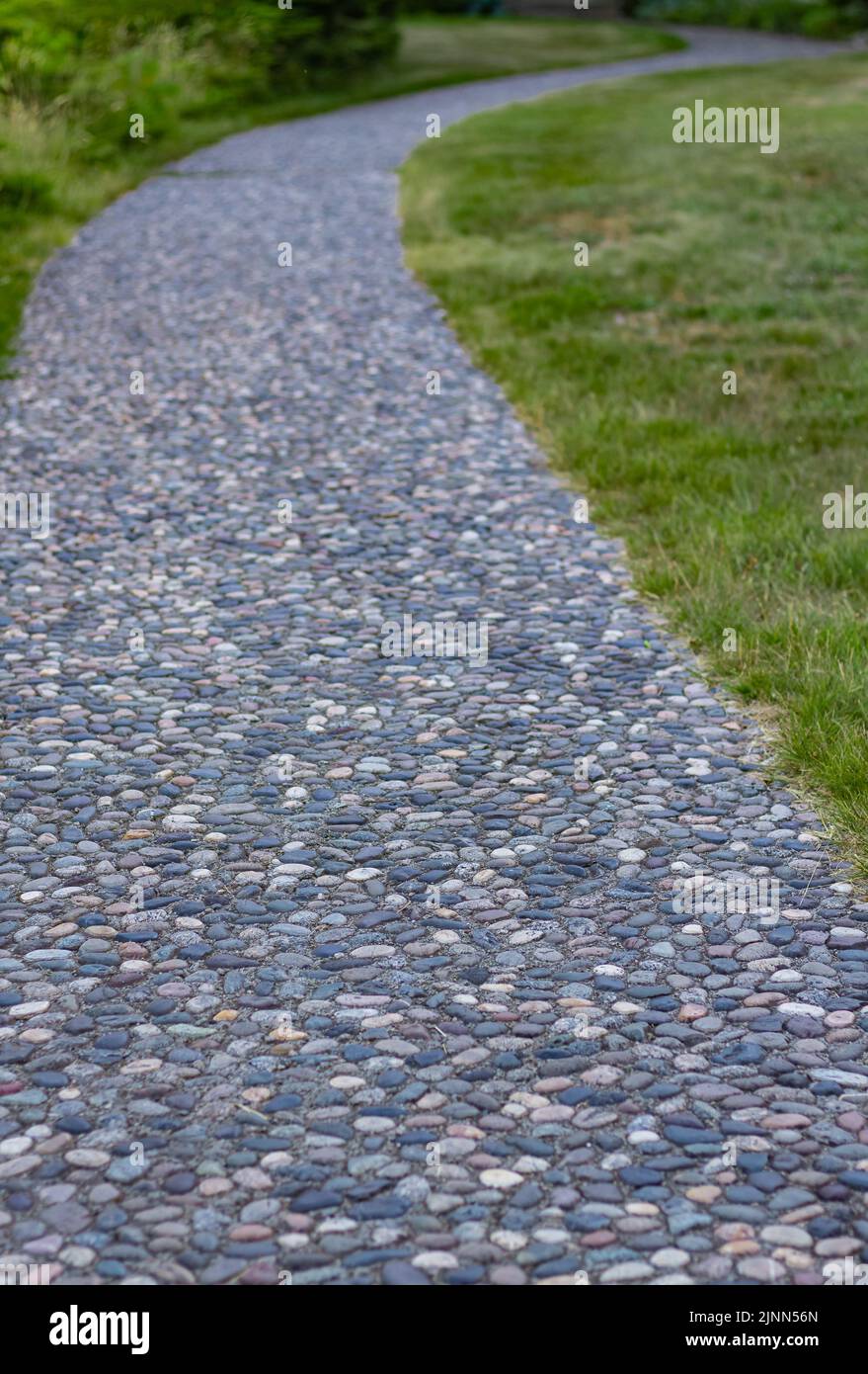 Massage Stein Gehweg Textur. Ein strukturiertes Pflaster mit Steinpflaster, Reflexzonenmassage. Kieselsteine auf dem Bürgersteig für Fußreflexzonenmassage. Die Kieselsteinböden. N Stockfoto