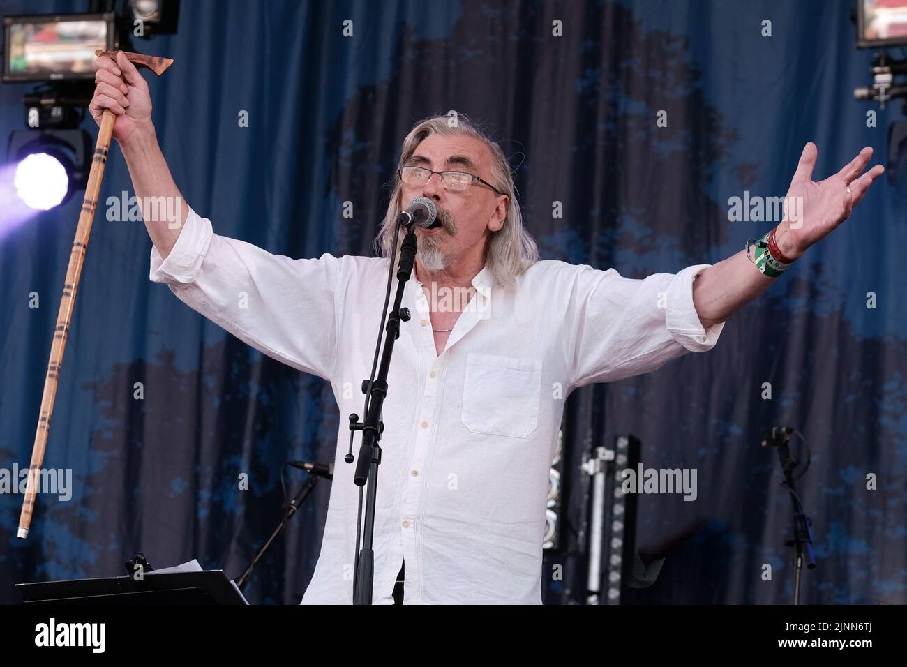 Cropredy, Großbritannien. 12. August 2022. John Tams, englischer Schauspieler, Sänger, Songwriter, Komponist und Musiker und Sohn eines Publikums, ehemaliges Mitglied der Derbyshire Folk-Gruppe Muckram, wacht auf, während die britische Folk-Rock-Gruppe Home Service live auf der Bühne des Cropredy Festivals der Fairport Convention auftrat. Home Service ist eine britische Folk-Rock-Gruppe, die Ende 1980 aus einem Kern von Musikern gegründet wurde, die in Ashley Hutchings' Albion Band gespielt hatten. Ihre Karriere ist allgemein vereinbart, mit dem Album Alright Jack ihren Höhepunkt erreicht zu haben und hat einen Einfluss auf die spätere Arbeit, die John Tams und mehrere andere Mitglieder der Band haben, gehabt Stockfoto