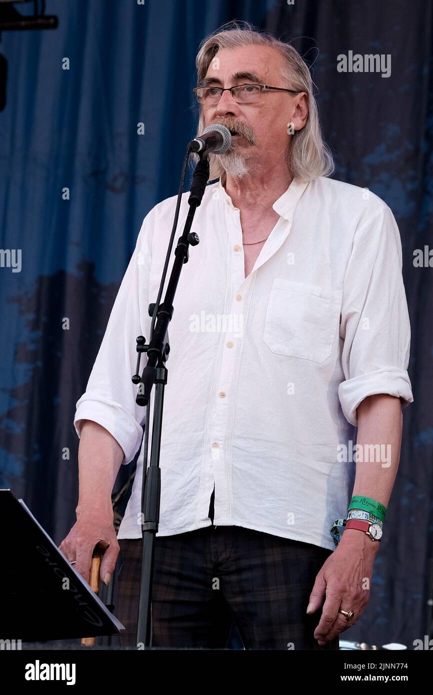 John Tams, englischer Schauspieler, Sänger, Songwriter, Komponist und Musiker und Sohn eines Publikums, ehemaliges Mitglied der Derbyshire Folk-Gruppe Muckram, wacht auf, während die britische Folk-Rock-Gruppe Home Service live auf der Bühne des Cropredy Festivals der Fairport Convention auftrat. Home Service ist eine britische Folk-Rock-Gruppe, die Ende 1980 aus einem Kern von Musikern gegründet wurde, die in Ashley Hutchings' Albion Band gespielt hatten. Ihre Karriere ist allgemein vereinbart, mit dem Album Alright Jack ihren Höhepunkt erreicht zu haben und hat Einfluss auf die spätere Arbeit von John Tams und mehreren anderen Mitgliedern der Band gehabt, Solokarrieren gehabt und ich gearbeitet Stockfoto