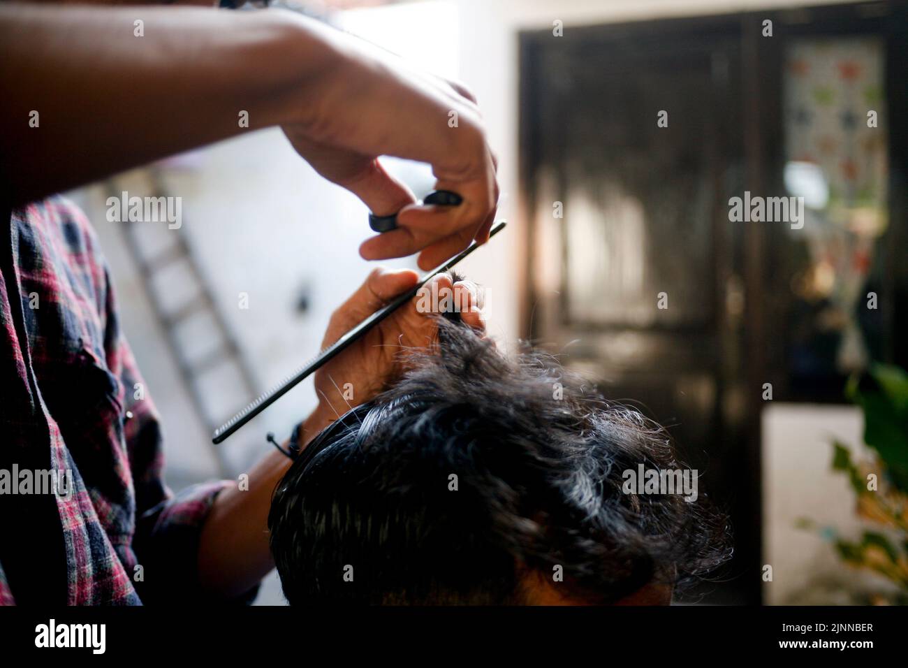 Asiatischer junger Mann Barbier schneidet schwarzes Haar Stockfoto