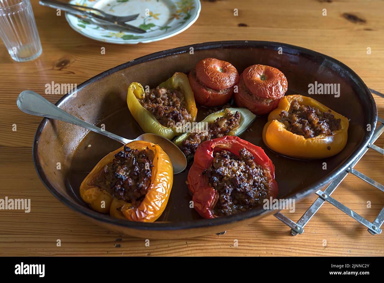 Gefüllte Paprika und Tomaten in einer Kasserolle auf dem Esstisch, Bayern, Deutschland Stockfoto