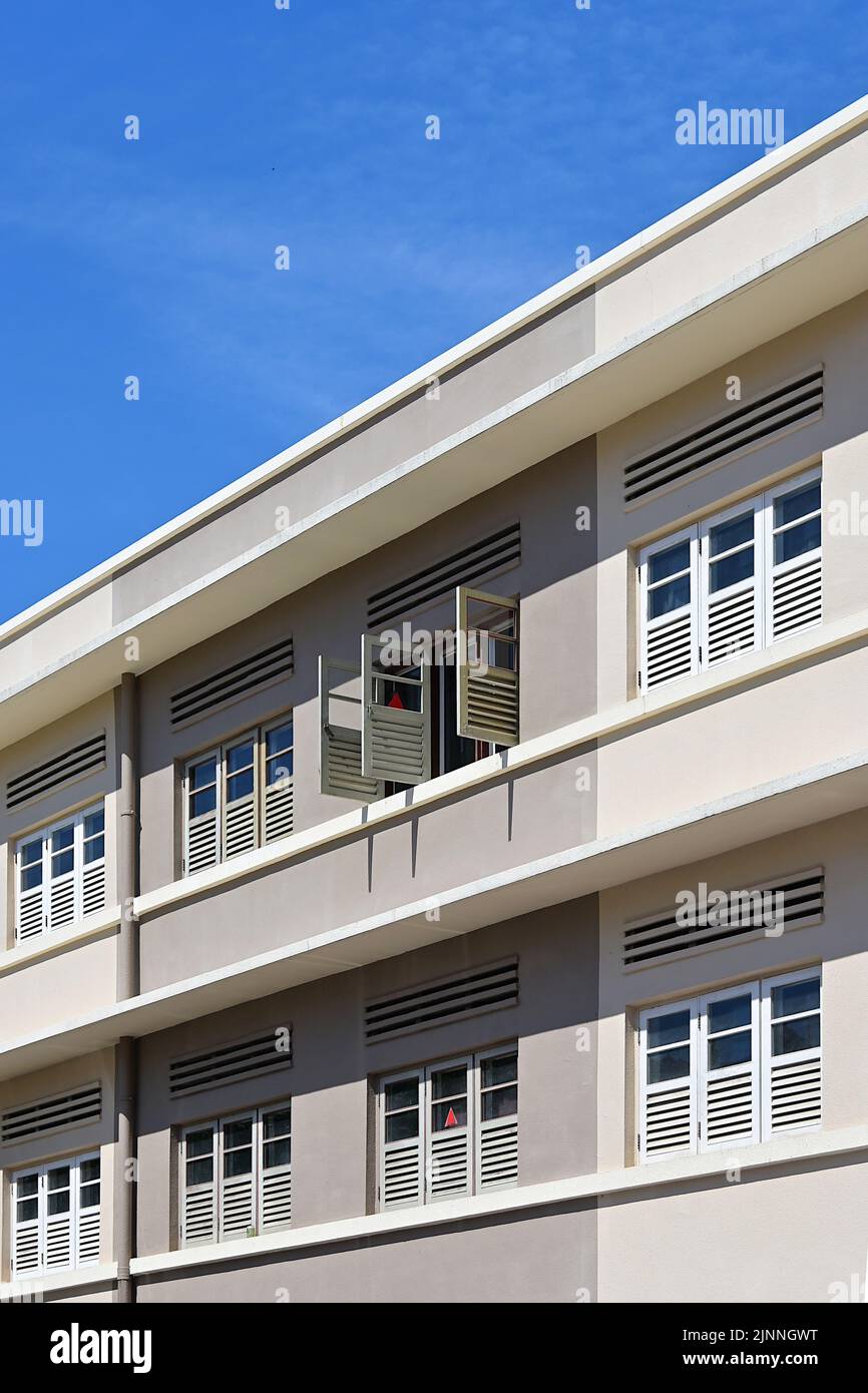 Belüftungsöffnungen und Lamellenfenster entlang der Außenseite des renovierten Vorkriegsgebäudes im modernen Art-Deco-Stil, Südostasien Stockfoto
