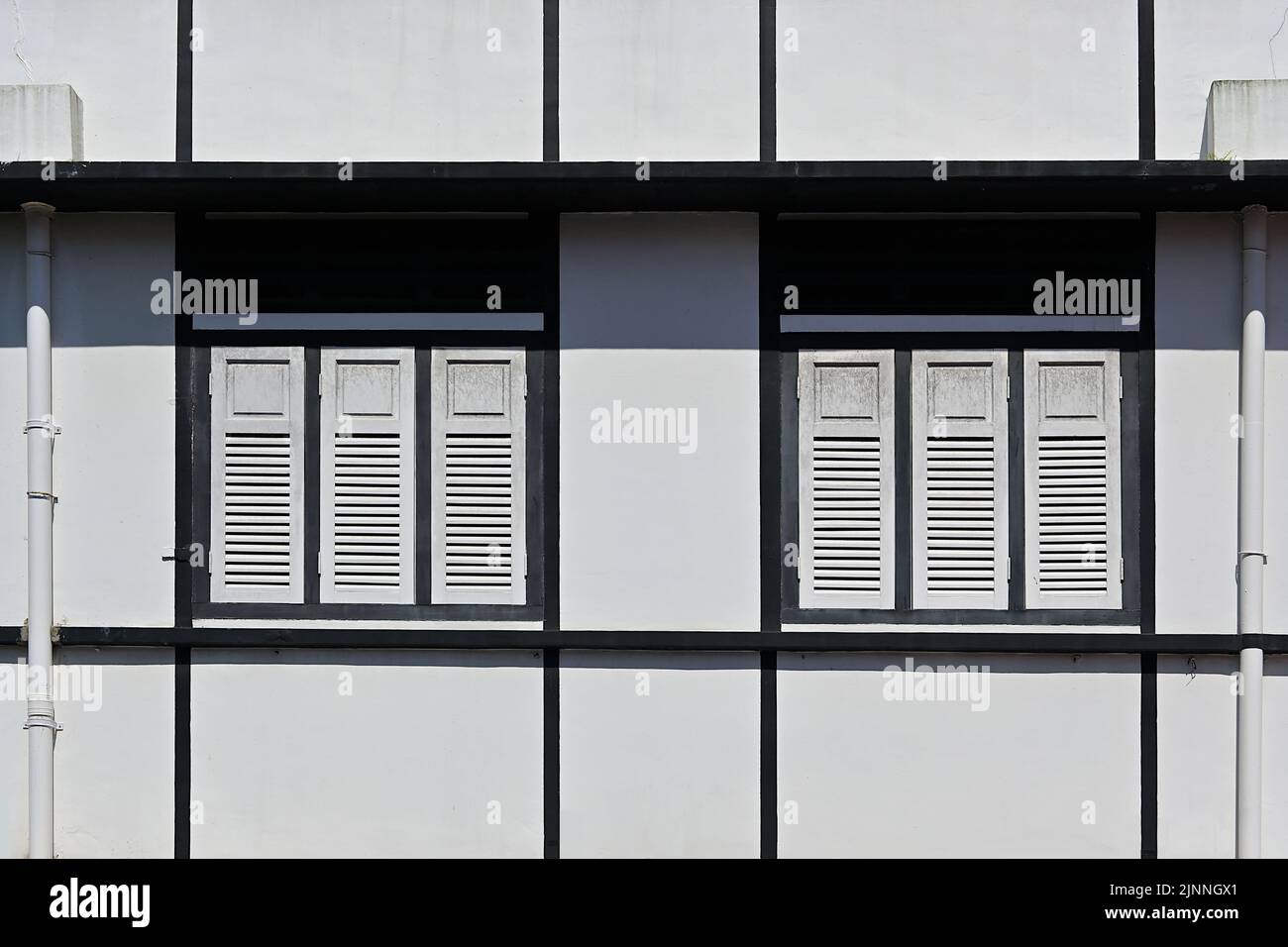 Fassade eines renovierten Vorkriegsgebäudes im stromlinigen modernen Art-Deco-Stil mit hölzernen Lamellenfenstern und Lüftungsschlitzen, Südostasien Stockfoto