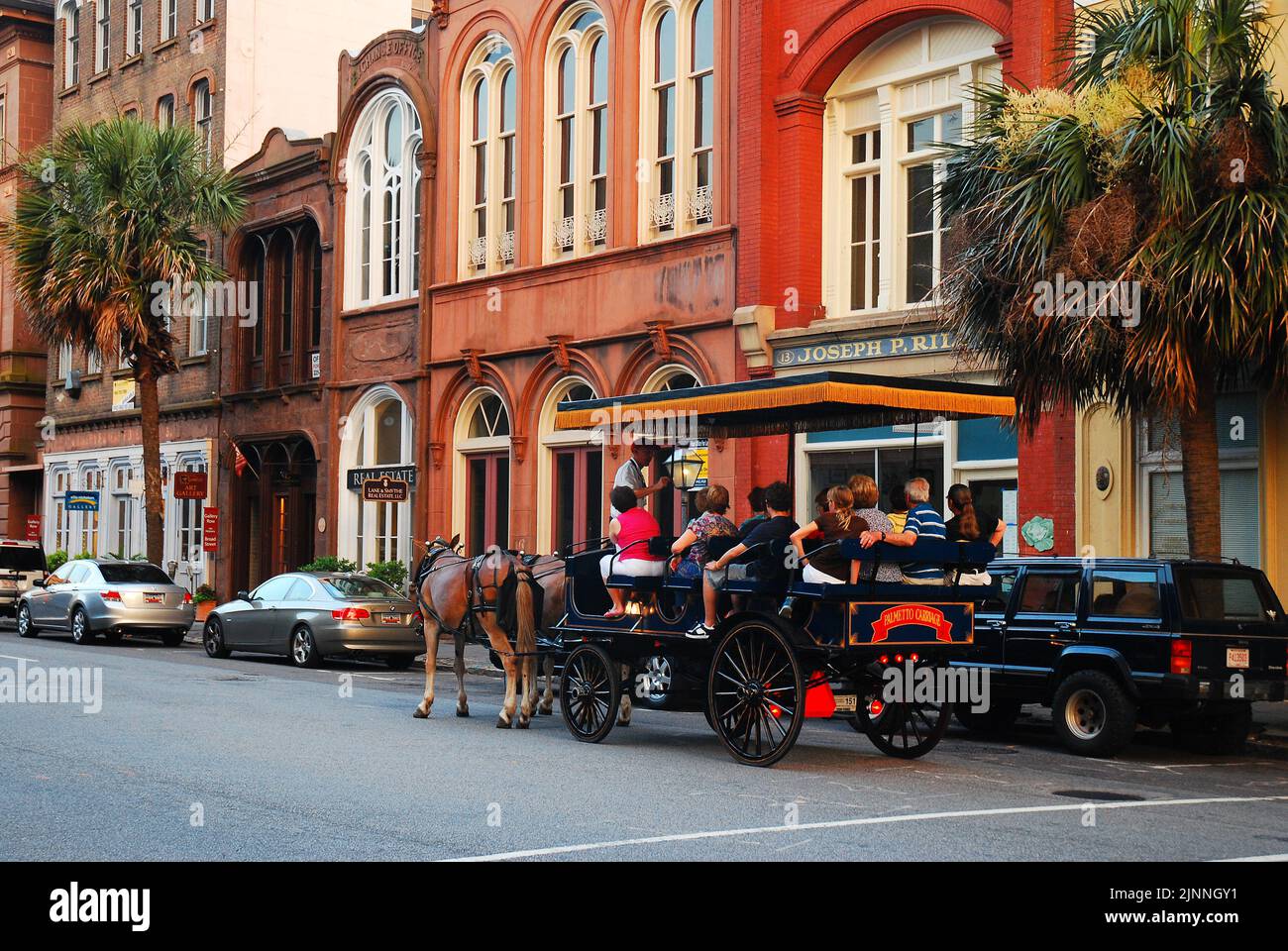 Eine Gruppe von Touristen genießen eine langsame, Pferdekutschenfahrt zu den historischen Stätten und Gebäuden der charmanten Stadt Charleston, South Carolina Stockfoto