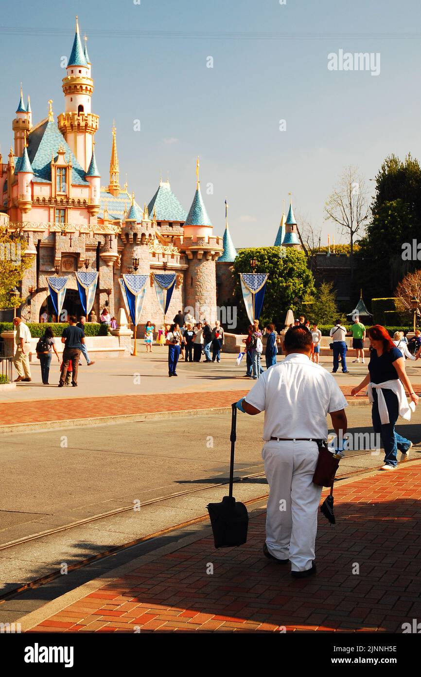 Ein Darsteller von Disneyland geht durch den Themenpark, in der Nähe von Cinderella's Castle, nimmt Müll auf und sorgt dafür, dass der Park ordentlich gehalten wird Stockfoto