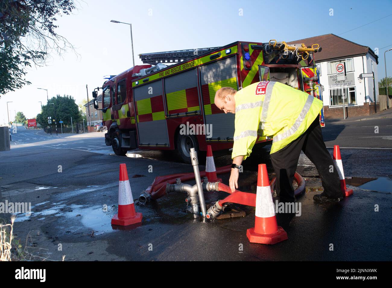 Slough, berkshire, Großbritannien. 13.. August 2022. Ein Löschmotor bezieht Wasser aus einem Hydranten. Royal Berkshire Fire and Rescue Service lösten heute Morgen ein Feuer in der Simpson Recycling-Anlage in Simpsons Way, Slough, hinter dem Ramgarhia Sikh Tempel. Den Anwohnern wurde geraten, drinnen zu bleiben und ihre Fenster geschlossen zu halten. Ein Zetros Feuerwehrwagen, der 8.000 Liter Wasser fasst, war ebenfalls vor Ort, um das Feuer zu dämpfen. Quelle: Maureen McLean/Alamy Live News Stockfoto