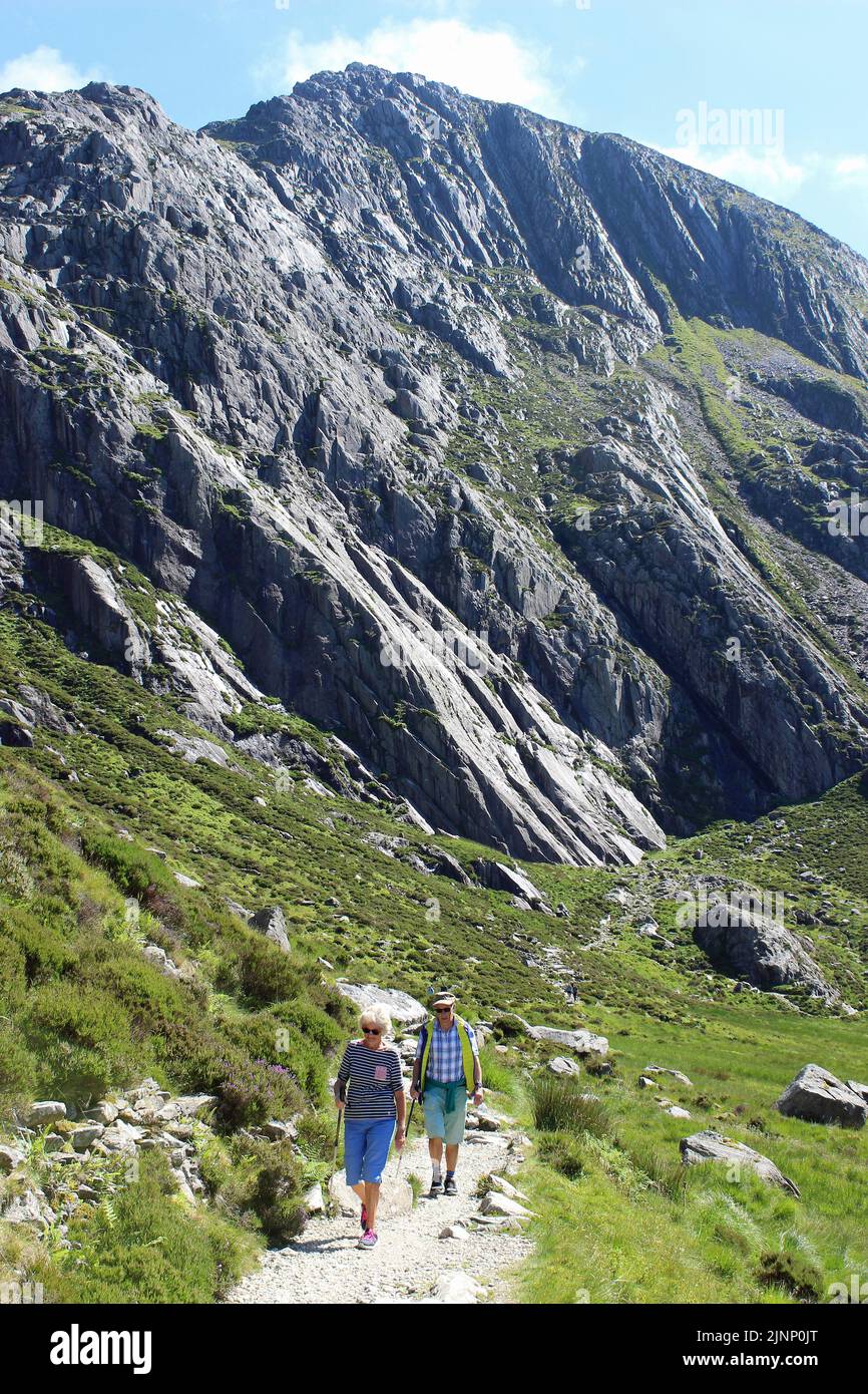 Zwei Senior Walkers Auf Dem Weg Um Llyn Idwal, Die Berühmten Idwal Platten Im Hintergrund Stockfoto