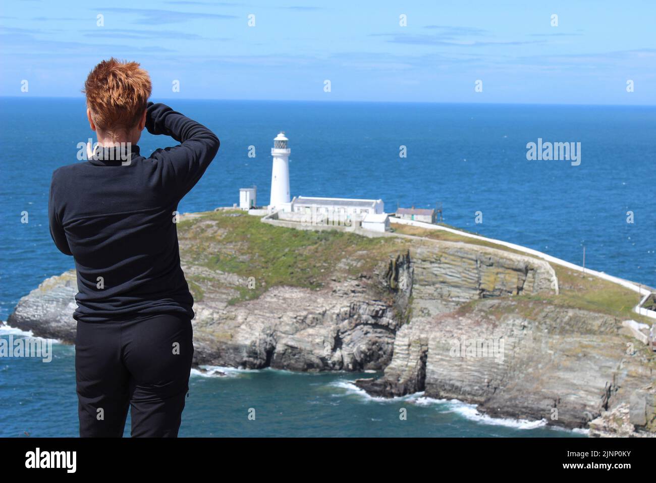 Tourist macht ein Foto vom South Stack Lighthouse, Anglesey Stockfoto