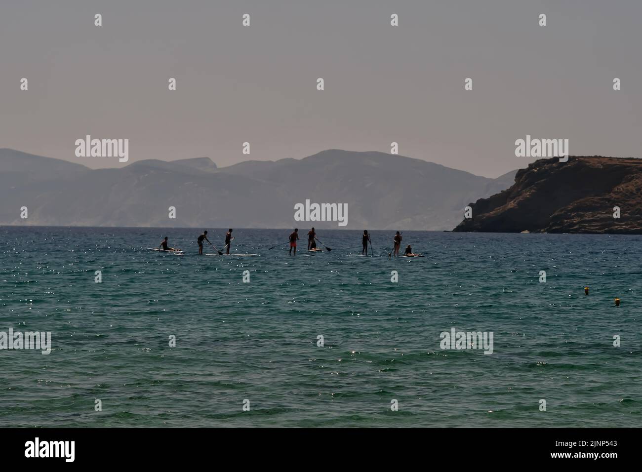 IOS, Griechenland - 8. Juni 2021 : Junge Touristen genießen Stand-up-Paddle-Boarding am berühmten Strand von Mylopotas iOS Greece Stockfoto