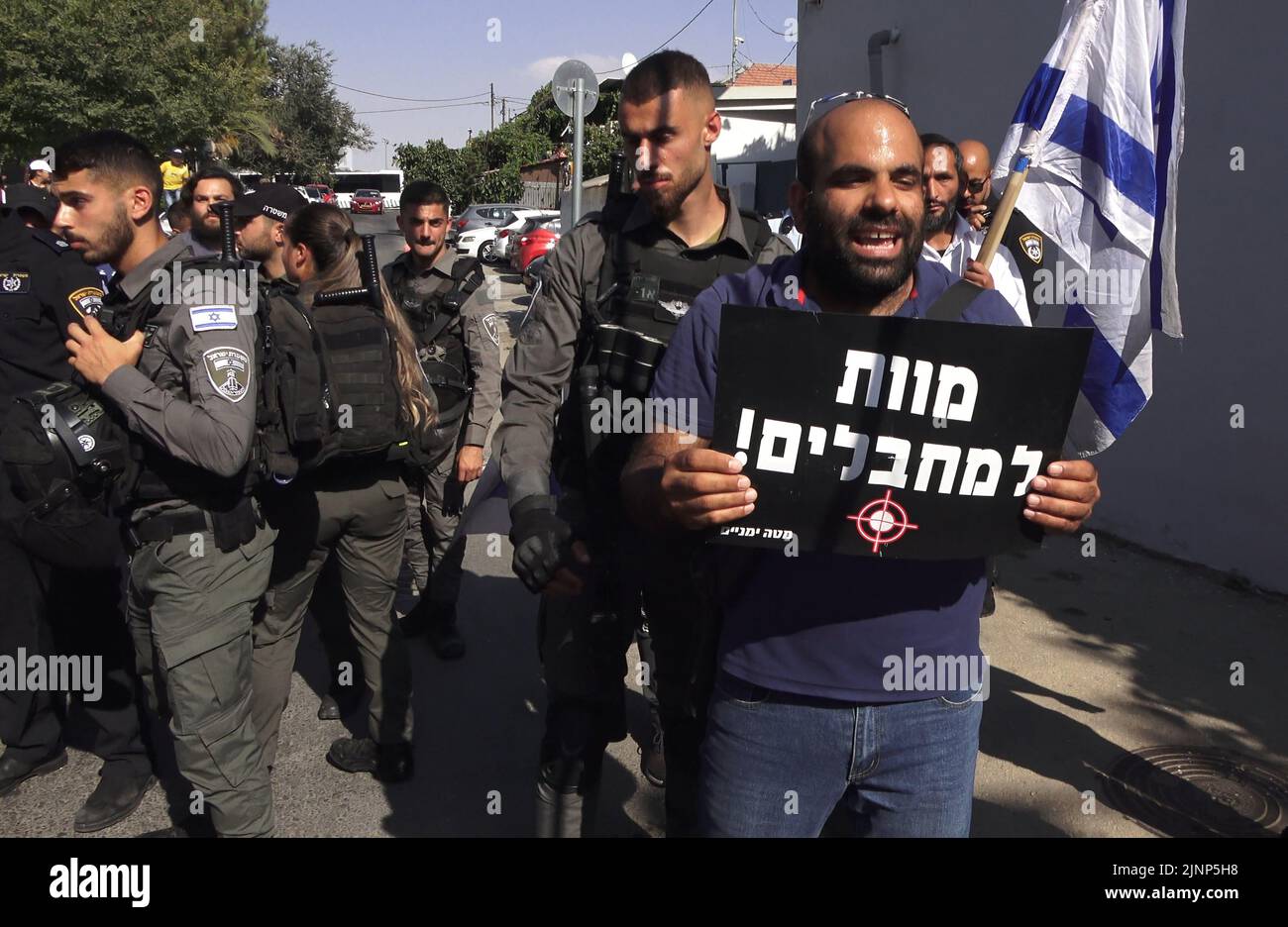 Ein rechter Gegenprotzer hält ein Schild mit der Aufschrift „Tod den Terroristen“, als er israelische linke Aktivisten und Palästinenser konfrontiert, die am 12. August 2022 in Jerusalem, Israel, an einer Demonstration gegen israelische Besatzung und Siedlungsaktivitäten im Stadtteil Sheikh Jarrah teilnehmen. Das palästinensische Viertel Sheikh Jarrah ist derzeit das Zentrum einer Reihe von Eigentumsstreitigkeiten zwischen Palästinensern und rechtsgerichteten jüdischen Israelis. Einige Häuser wurden nach einem Gerichtsurteil von israelischen Siedlern besetzt Stockfoto