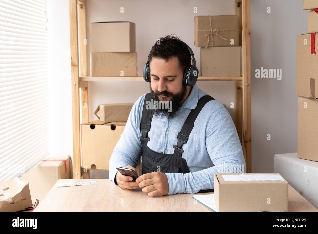 SME. Gutaussehende Millennial Lieferung Mann Musik hören nehmen Auftrag