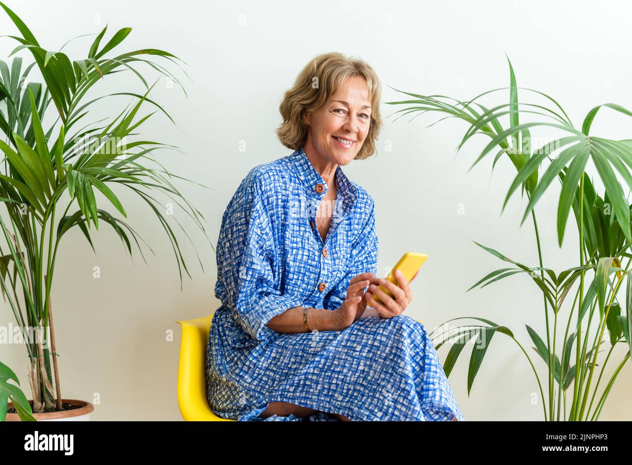 Schöne reife ältere Frau zu Hause, häusliches Leben und Freizeit Momente - 50-60 Jahre alt hübsche weibliche Erwachsene mit Handy Stockfoto