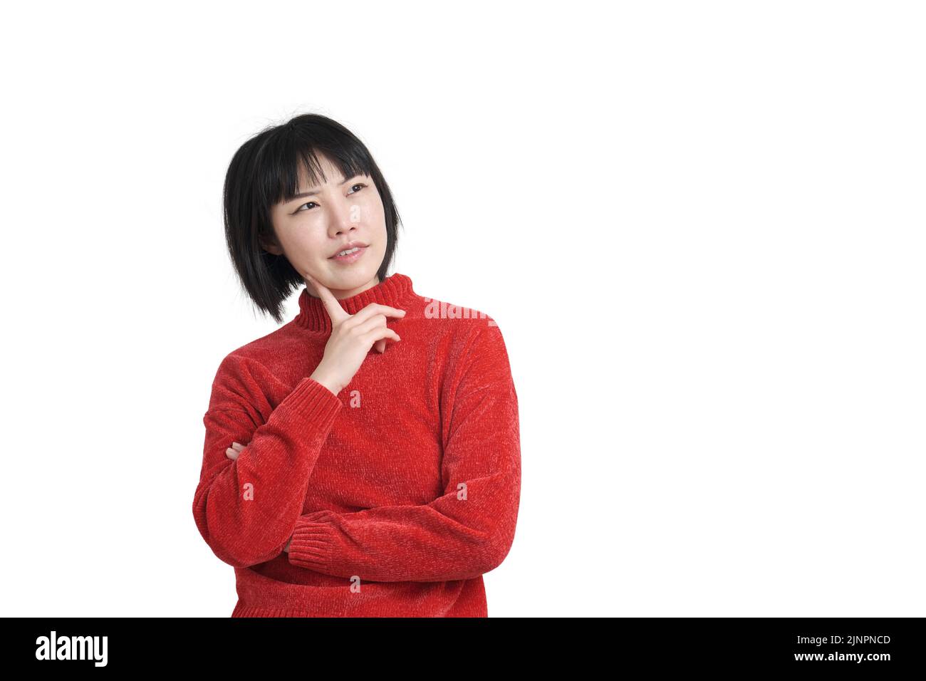 Junge asiatische Frau, die ihr Kinn mit nachdenklicher Gesichtsausdruck berührt, isoliert. Stockfoto