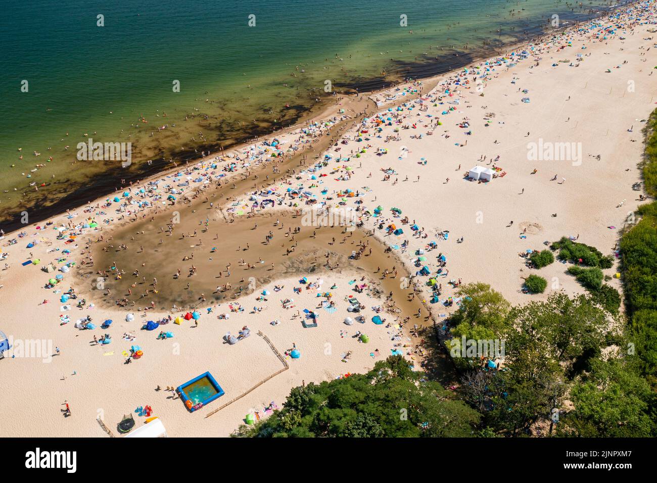 Ostseeküste, Baden im Meer und im Oliwski-Bach münden die Menschen während des heißen Sommerwochenendes ins Meer Stockfoto