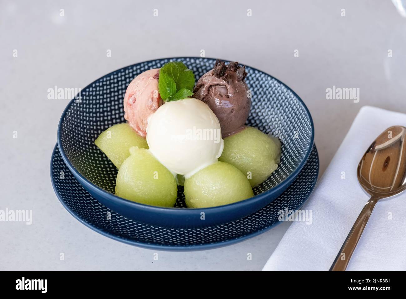 Fruchteis auf Melonenbällen auf Marmortisch Stockfoto