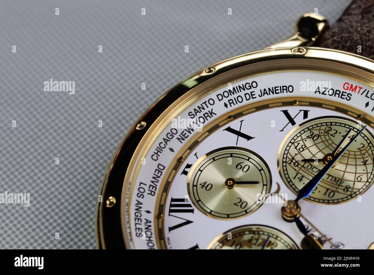 Nahaufnahme der Zeitzonennamen der Städte auf der luxuriösen Weltzeit-Uhrenblende. Stockfoto