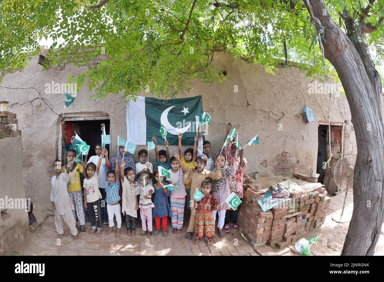 Die Kinder und Arbeiter der United Social Welfare Society von pakistanischen Ziegelöfen feiern den Unabhängigkeitstag 75. am Ziegelofen in Lahore. Der Unabhängigkeitstag (Y?um-e-?z?di), der jährlich am 14. August begangen wird, ist ein Nationalfeiertag in Pakistan. Es erinnert an den Tag, an dem Pakistan seine Unabhängigkeit erlangte und nach dem Ende des britischen Raj im Jahr 1947 zum souveränen Staat erklärt wurde. Pakistan entstand durch die Pakistan-Bewegung, die die Schaffung eines unabhängigen muslimischen Staates in den nordwestlichen Regionen des britischen Indiens durch Teilung anstrebte. Die Bewegung Stockfoto