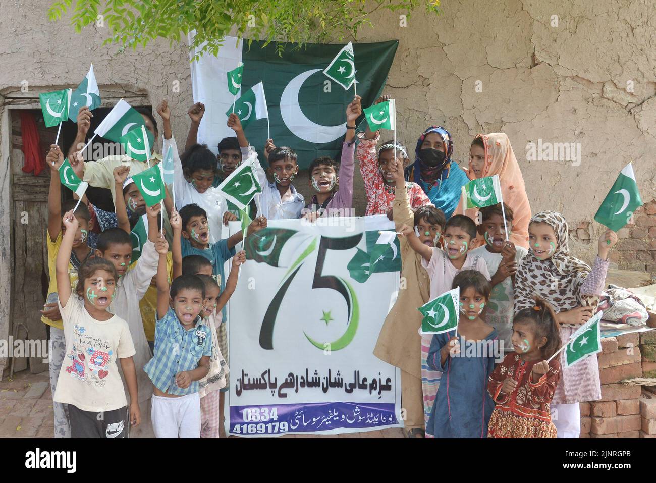 Die Kinder und Arbeiter der United Social Welfare Society von pakistanischen Ziegelöfen feiern den Unabhängigkeitstag 75. am Ziegelofen in Lahore. Der Unabhängigkeitstag (Y?um-e-?z?di), der jährlich am 14. August begangen wird, ist ein Nationalfeiertag in Pakistan. Es erinnert an den Tag, an dem Pakistan seine Unabhängigkeit erlangte und nach dem Ende des britischen Raj im Jahr 1947 zum souveränen Staat erklärt wurde. Pakistan entstand durch die Pakistan-Bewegung, die die Schaffung eines unabhängigen muslimischen Staates in den nordwestlichen Regionen des britischen Indiens durch Teilung anstrebte. Die Bewegung Stockfoto