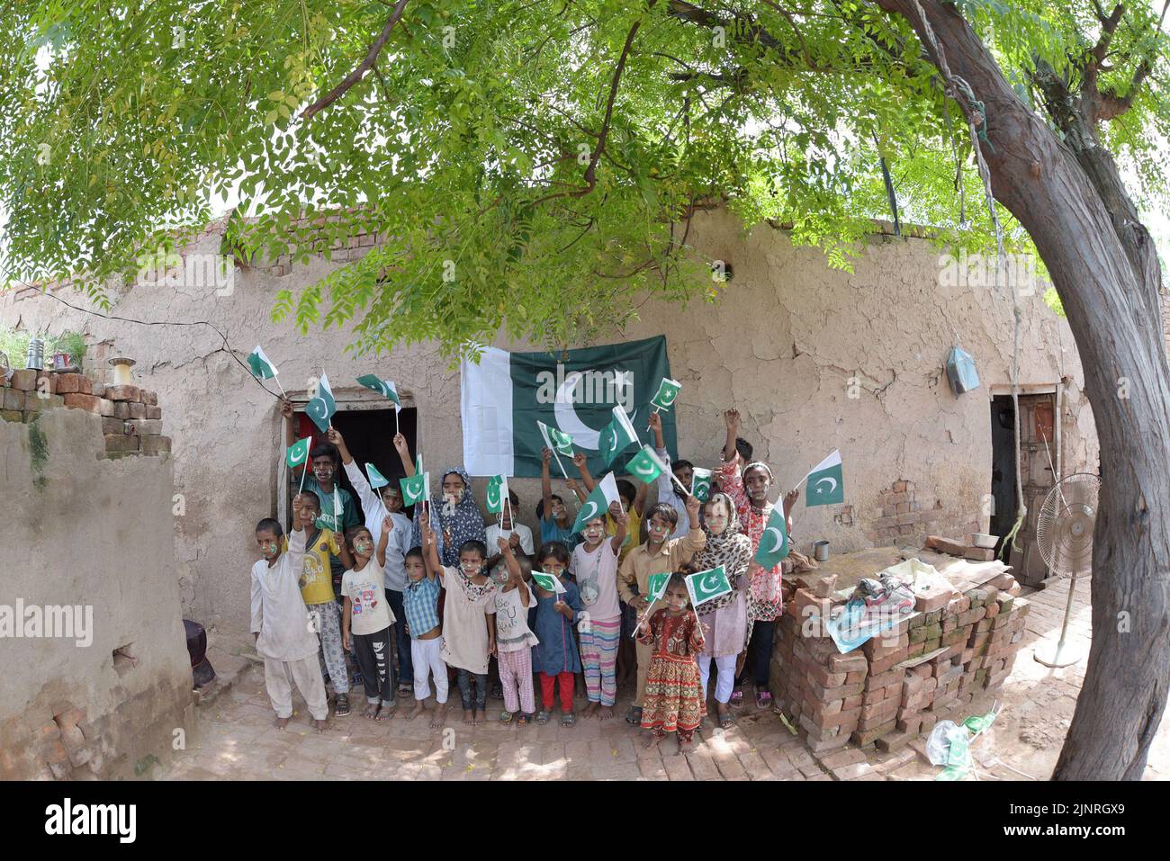 Die Kinder und Arbeiter der United Social Welfare Society von pakistanischen Ziegelöfen feiern den Unabhängigkeitstag 75. am Ziegelofen in Lahore. Der Unabhängigkeitstag (Y?um-e-?z?di), der jährlich am 14. August begangen wird, ist ein Nationalfeiertag in Pakistan. Es erinnert an den Tag, an dem Pakistan seine Unabhängigkeit erlangte und nach dem Ende des britischen Raj im Jahr 1947 zum souveränen Staat erklärt wurde. Pakistan entstand durch die Pakistan-Bewegung, die die Schaffung eines unabhängigen muslimischen Staates in den nordwestlichen Regionen des britischen Indiens durch Teilung anstrebte. Die Bewegung Stockfoto