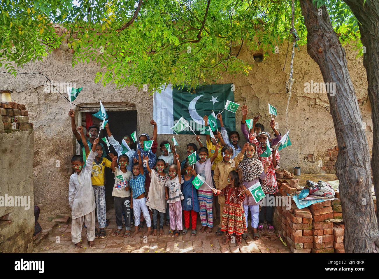 Lahore, Punjab, Pakistan. 12. August 2022. Die Kinder und Arbeiter der United Social Welfare Society von pakistanischen Ziegelöfen feiern den Unabhängigkeitstag 75. am Ziegelofen in Lahore. Der Unabhängigkeitstag (Y?um-e-?z?di), der jährlich am 14. August begangen wird, ist ein Nationalfeiertag in Pakistan. Es erinnert an den Tag, an dem Pakistan seine Unabhängigkeit erlangte und nach dem Ende des britischen Raj im Jahr 1947 zum souveränen Staat erklärt wurde. Pakistan entstand durch die Pakistan-Bewegung, die auf die Schaffung eines unabhängigen muslimischen Staates in den nordwestlichen Regionen abzielte Stockfoto