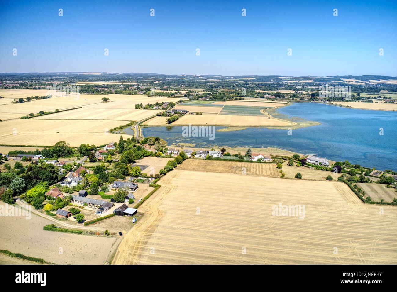 Luftaufnahme der kleinen Gemeinde Chidham in West Sussex, umgeben von Feldern zwischen der Mündung von Bosham und Thornham Marina. Stockfoto