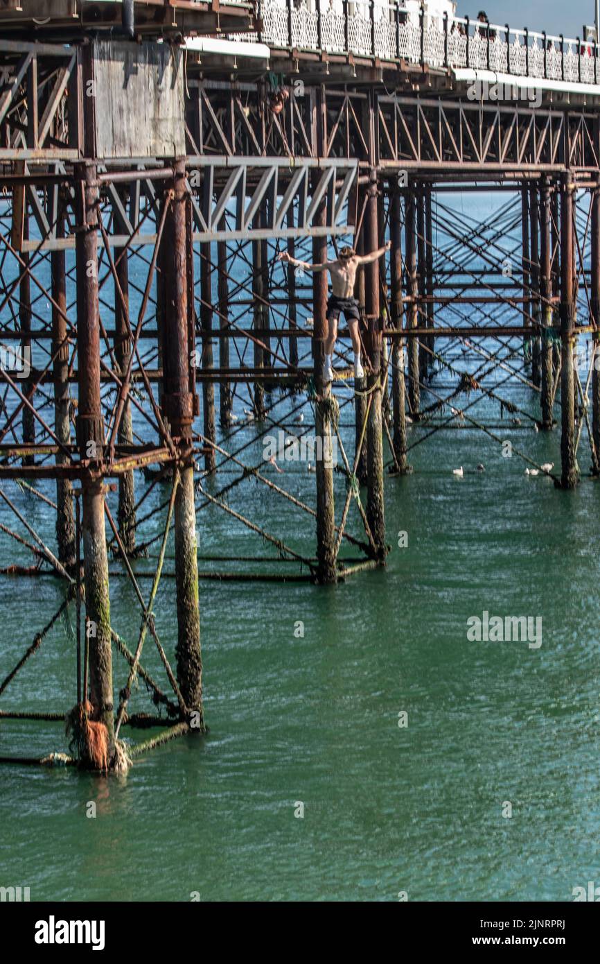 Brighton, Großbritannien. 13. August 2022. Tausende strömten diesen Samstag nach Brighton Beach und machten das Beste aus dem heißen Wetter. Ein See mit roten Schirmen (gesponsert von Walls Ice Cream) kann gesehen werden, die sich von Brighton bis Hove erstrecken Kredit: @Dmoonuk/Alamy Live News Stockfoto