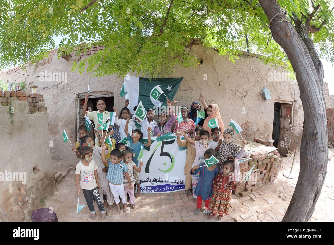 Lahore, Punjab, Pakistan. 12. August 2022. Die Kinder und Arbeiter der United Social Welfare Society von pakistanischen Ziegelöfen feiern den Unabhängigkeitstag 75. am Ziegelofen in Lahore. Der Unabhängigkeitstag (Y?um-e-?z?di), der jährlich am 14. August begangen wird, ist ein Nationalfeiertag in Pakistan. Es erinnert an den Tag, an dem Pakistan seine Unabhängigkeit erlangte und nach dem Ende des britischen Raj im Jahr 1947 zum souveränen Staat erklärt wurde. Pakistan entstand durch die Pakistan-Bewegung, die auf die Schaffung eines unabhängigen muslimischen Staates in den nordwestlichen Regionen abzielte Stockfoto