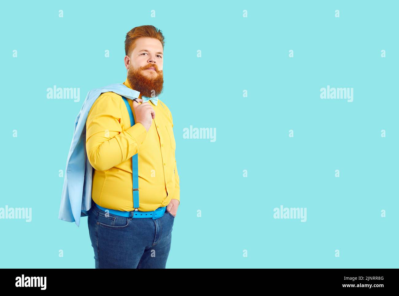 Rotschopf kaukasischer Mann mit Bart und Schnurrbart trägt gelbes Hemd und Jeans steht im Studio Stockfoto