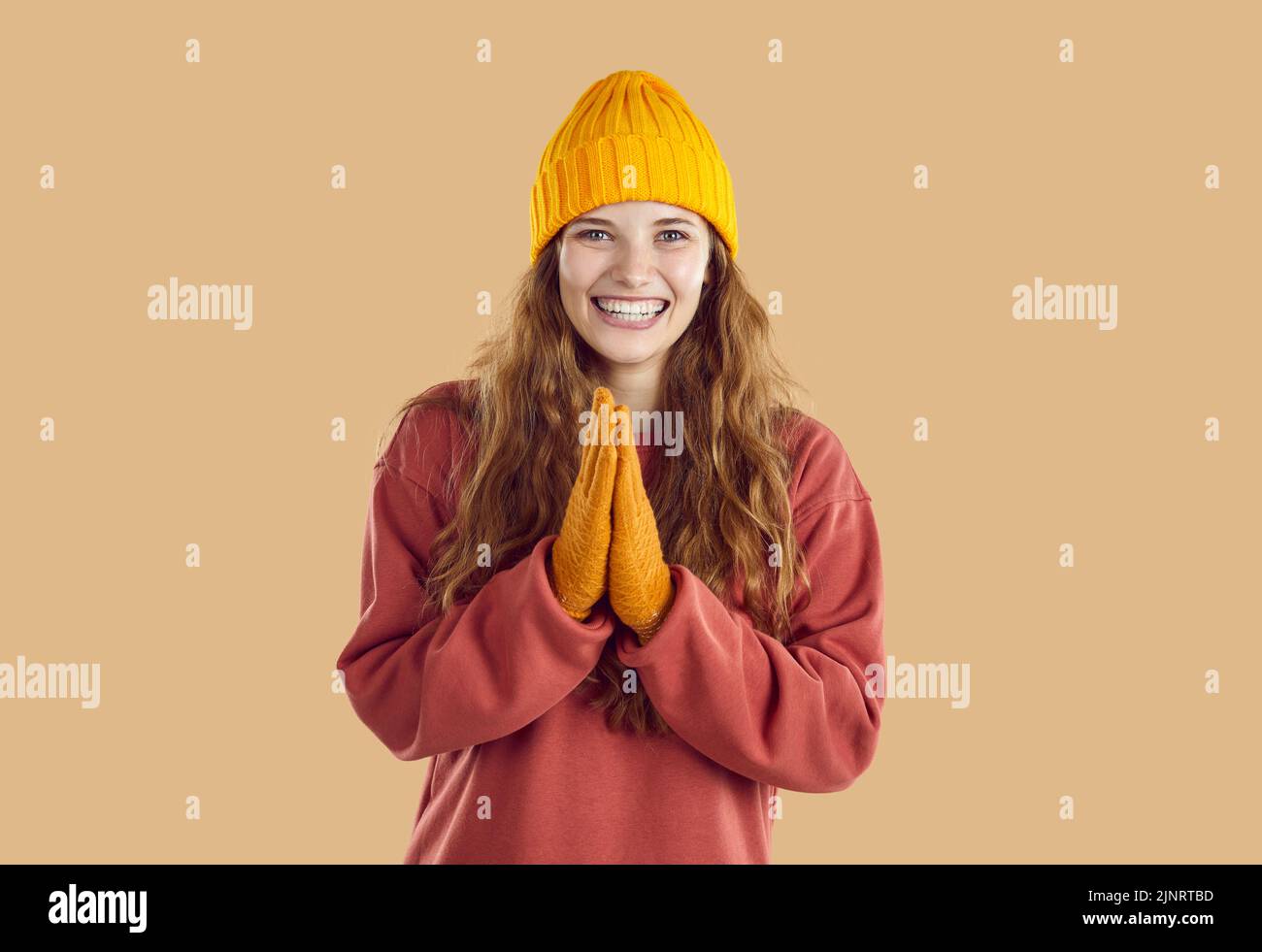 Aufgeregte glückliche Frau im Herbsthut und Handschuhe klatscht in die Hände und freut sich aufrichtig über gute Nachrichten. Stockfoto