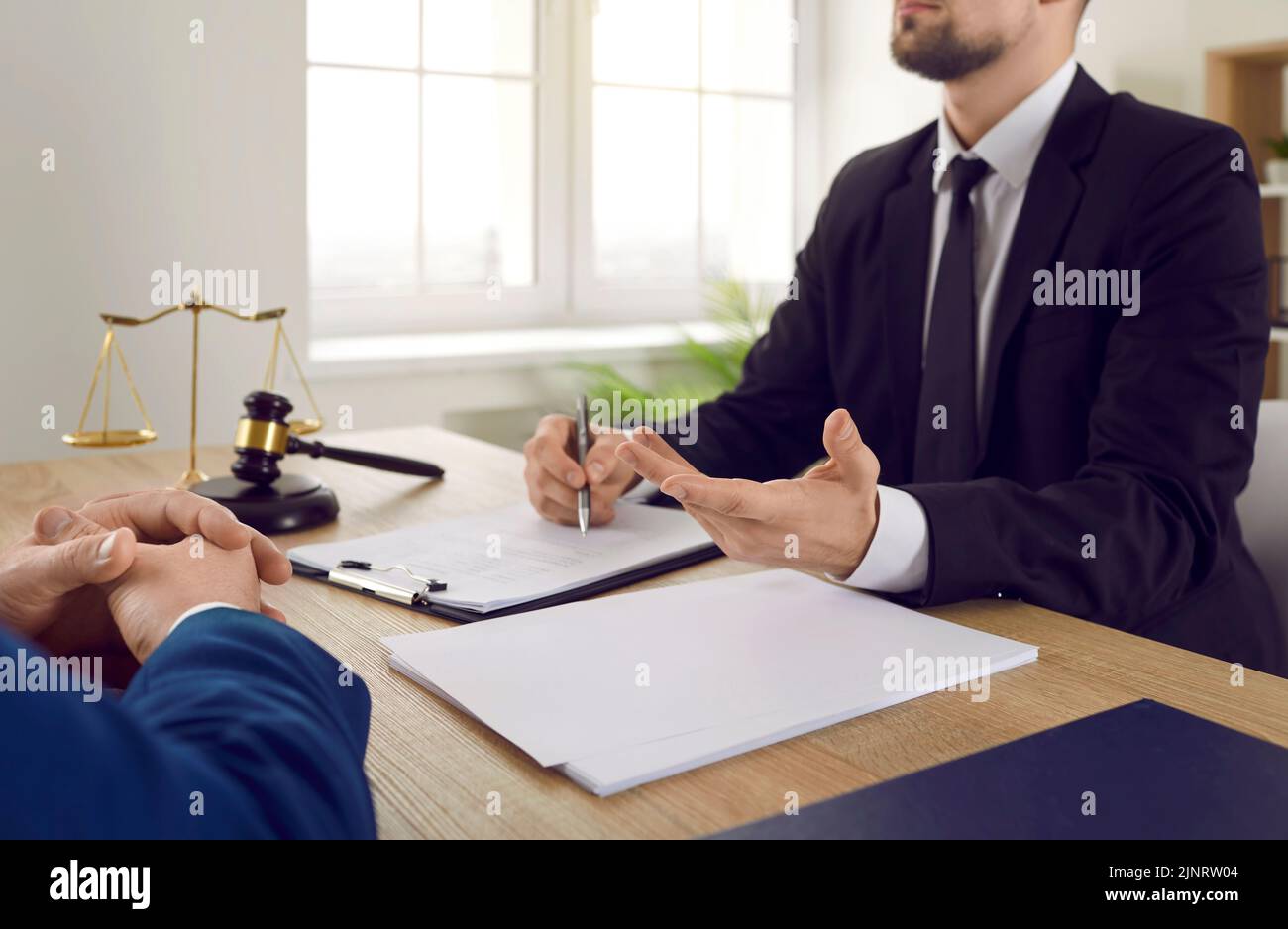 Rechtsanwalt oder Rechtsberater, der am Schreibtisch sitzt und über Vertragsvereinbarung mit dem Kunden spricht Stockfoto
