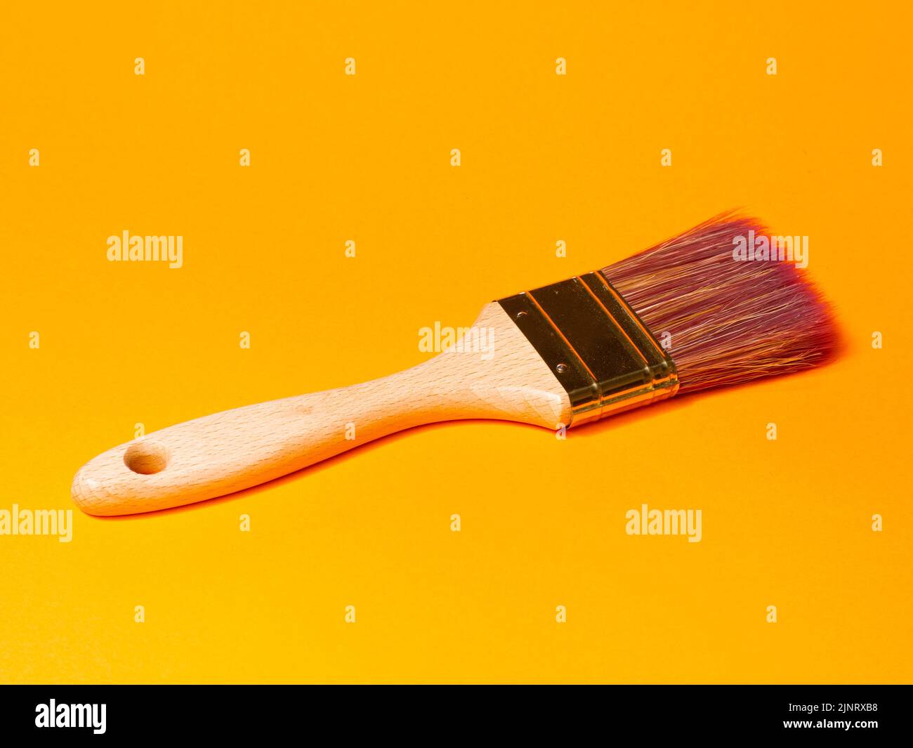 Pinsel auf orangefarbenem Hintergrund malen. Reformkonzept Stockfoto