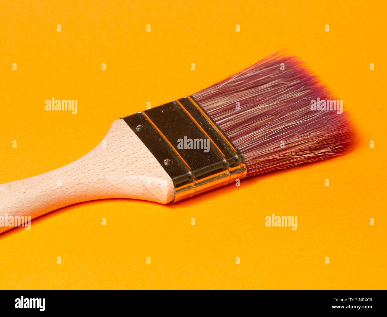 Pinsel auf orangefarbenem Hintergrund malen. Reformkonzept Stockfoto