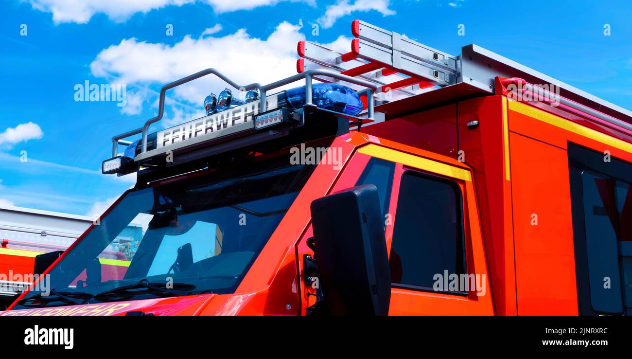 Nahaufnahme eines Feuerwehrwagens mit blauem Blitz vor blauem Himmel Stockfoto