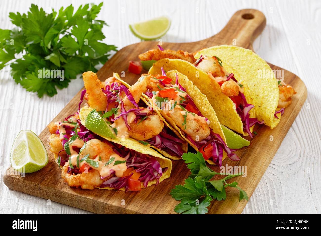 Nahaufnahme von Bang Bang Shrimp Tacos mit purpurfarbenem Kohl, Tomaten ...