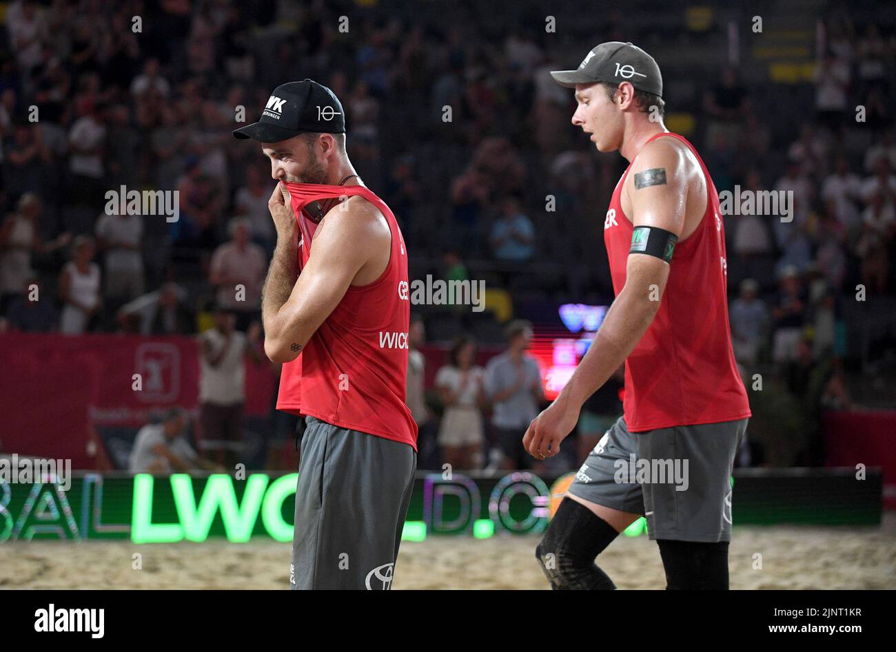 Hamburg, Deutschland. 13. August 2022. Beach Volleyball, Beach Pro Tour, Stadion am Rothenbaum. Die deutschen Spieler Clemens Wickler (l.) und Nils Ehlers verlassen nach der Niederlage enttäuscht das Gericht. Quelle: Michael Schwartz/dpa/Alamy Live News Stockfoto